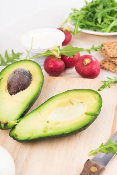 istock Green ripe avocado on wooden chopping board. 936416118