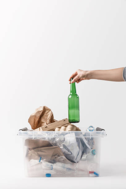 istock cropped shot of woman putting glass bottle into container with plastic bottles, recycle concept 936418708