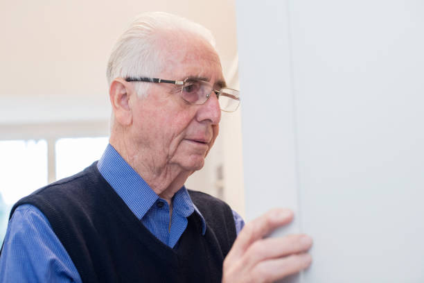 istock Forgetful Senior Man With Dementia Looking In Cupboard At Home 936418764