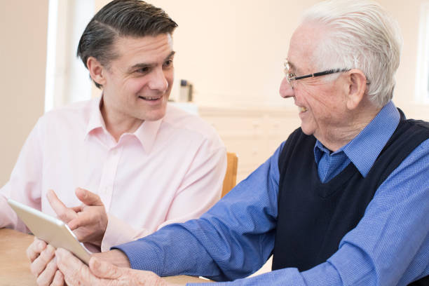 istock Male Neighbor Showing Senior Man How To Use Digital Tablet 936419230
