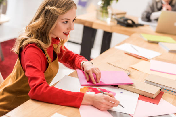istock smiling magazine editor working with sketches and documents in modern office 936419796