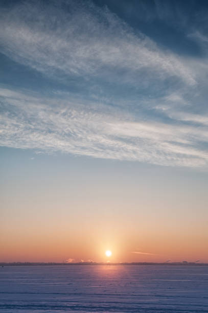 istock Cold winter landscape with snow, sky and sun on the horizon 936420082