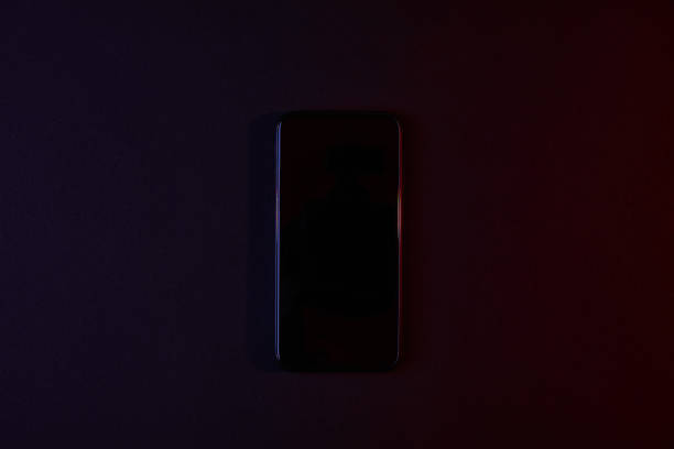 elevated view of one black smartphone on dark