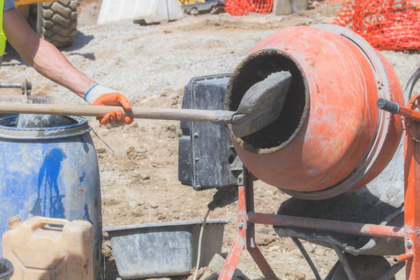 istock Construction worker on a cement / concrete mixer doing hard job. 936423928