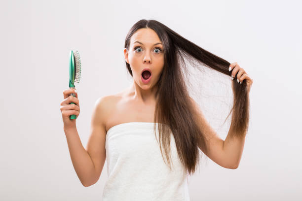 Hair Loss Beautiful woman  in panic because of hair loss looking at camera. hairbrush hair stock pictures, royalty-free photos & images