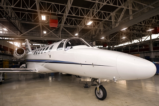 Private jet aircraft in the hangar open for regular maintenance service.