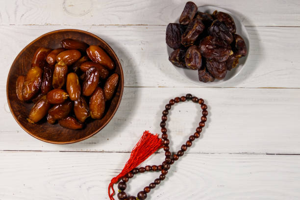 istock Dates fruit and prayer beads on white wooden table. Top view 936426586