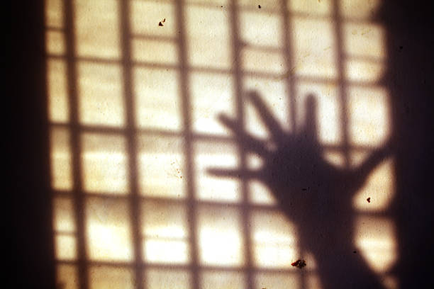 close up shadow of hands in jail background. close up shadow of hands in jail background. kidnapping photos stock pictures, royalty-free photos & images