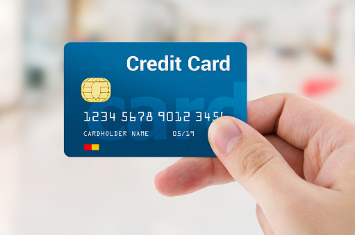 Man hand holding personal credit or debit card. Credit card payment in shop concept