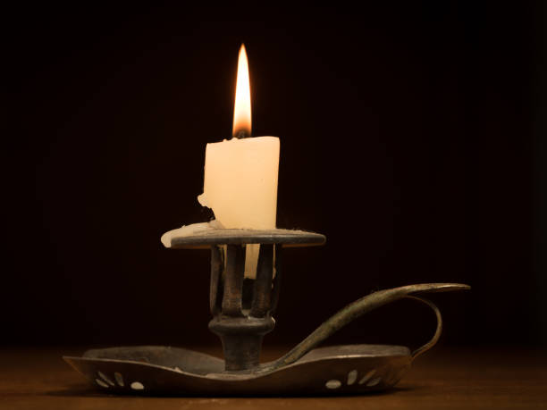 istock Nearly burnt down burning candle on an old metallic candle holder 936427678