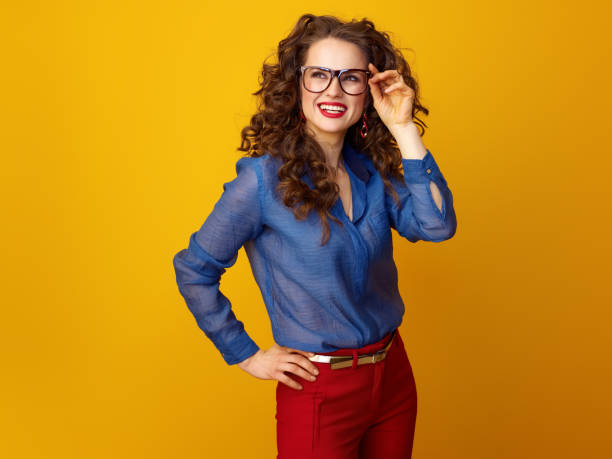 istock woman in glasses on yellow background looking at copy space 936427854