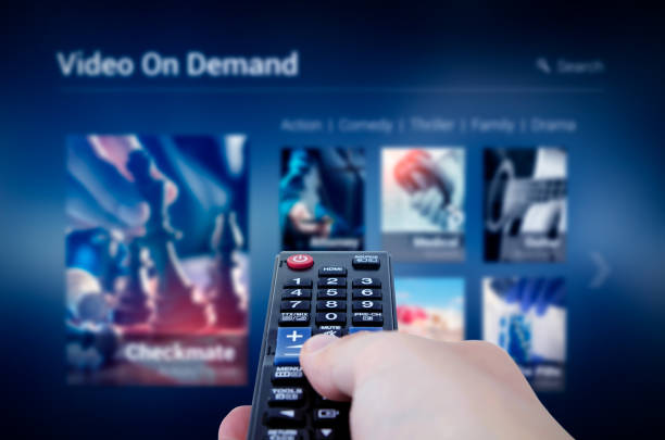 VOD service screen with remote control in hand VOD service screen with remote control in hand. Video On Demand television internet stream multimedia concept 4k resolution stock pictures, royalty-free photos & images