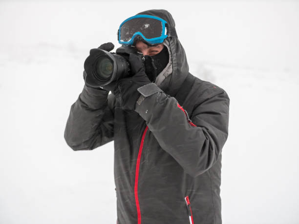 istock Professional photographer shooting with his camera outdoors in the snowy mountain 936429206