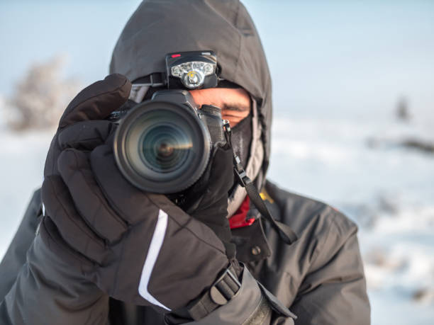 istock Front view of professional photographer pointing his digital camera forward 936429932