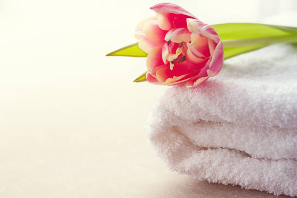 istock Spa concept with white towel and tulip flowers on beige background 936430514