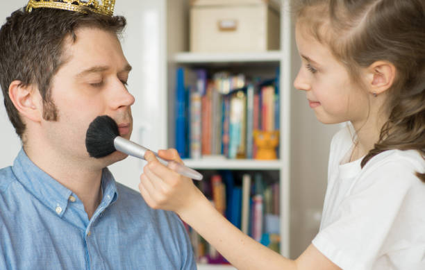 istock Cute little girl making makeup to her dad. 936433686