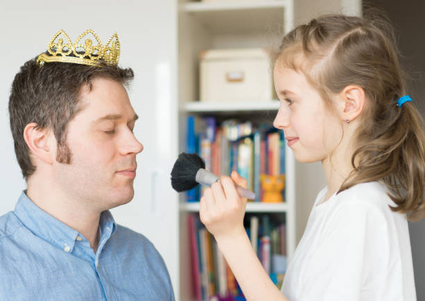 istock Cute little girl making makeup to her dad. 936433726