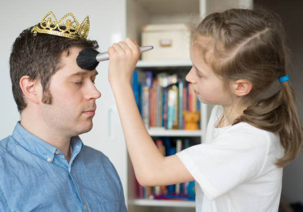 istock Cute little girl making makeup to her dad. 936433772