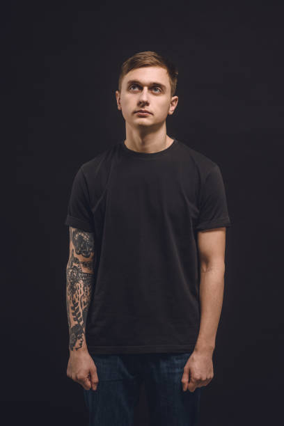 istock Young man with tattooed arm isolated on black 936434326