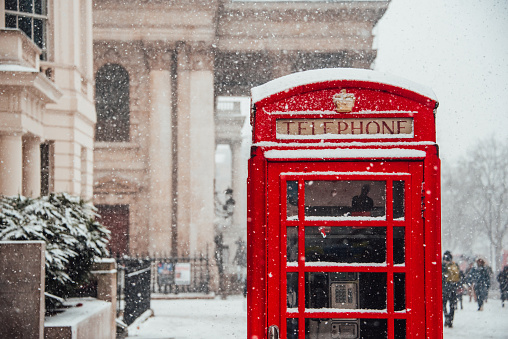 Snow falling over London - Snow flakes falling by a red telephone booth