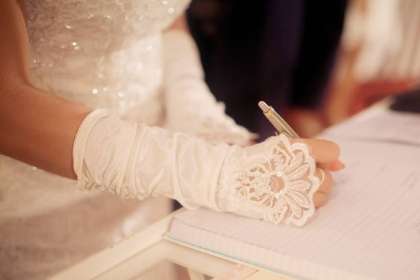 Bride signing marriage license or wedding contract during ceremony. Woman sign the document/ertificate/contract for marriage