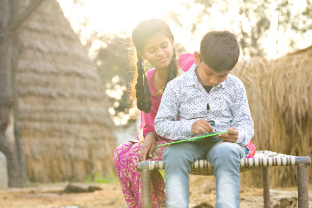 istock Girl with little brother writing on slate 936439552