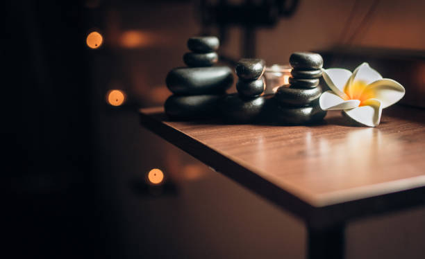 Lit candles and black massage stones in Zen spa