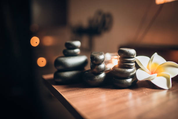 istock Lit candles and black massage stones in Zen spa 936441714