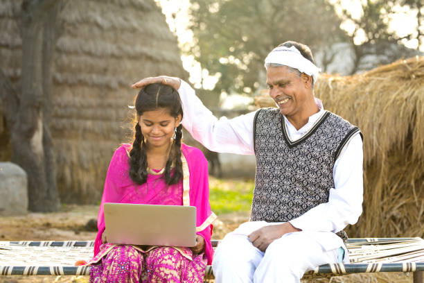Father with daughter using laptop Father with daughter using laptop on traditional bed in village bed of hay stock pictures, royalty-free photos & images