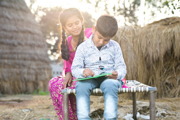 istock Girl with little brother writing on slate 936444078