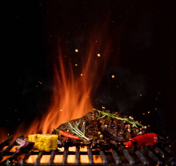 istock Fiery grill grid with piece of beef steak and grilled vegetable. 936446062