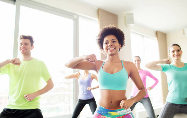 istock group of happy people exercising or dancing in gym 936446154