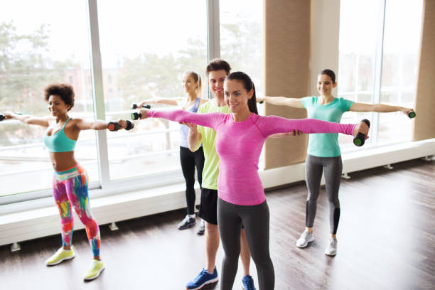 istock group of smiling people working out with dumbbells 936446326