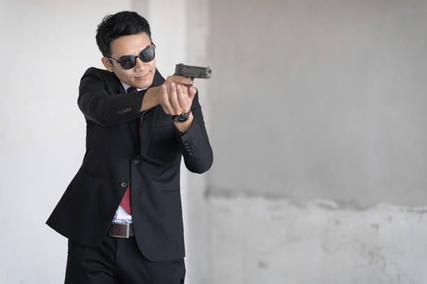 istock Handsome man with sunglass is aim the gun. Selective focus at his face. 936448954