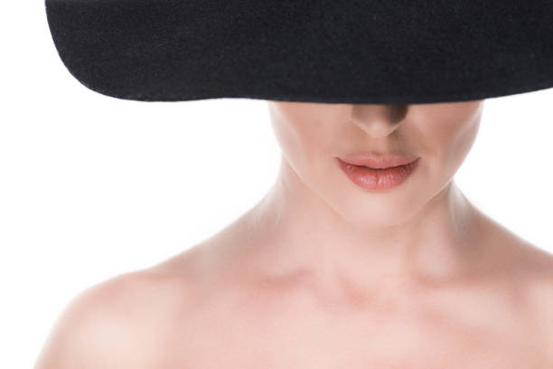 Black-and-white portrait of a woman wearing a tall top hat, her eyes closed as if caught in a moment of quiet imagination. The photograph evokes the act of wishing — a still, enchanted instant between dream and reality, where identity dissolves into light and possibility.