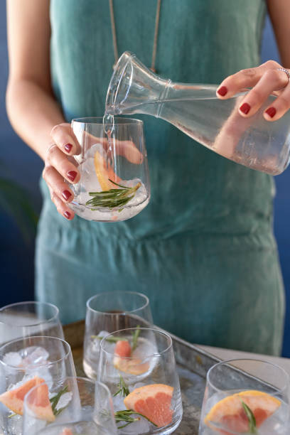 istock Woman pouring drinks making gin and tonics for a cocktail party 936460370