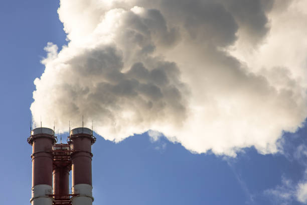 istock smoke coming out of pipes into the clear blue sky, ecology problems 936465820