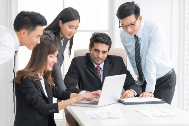 istock A confident business team of mixed ages using labtop computer thegether for meeting in a modern office. They are discussing ideas for their business development 936468288