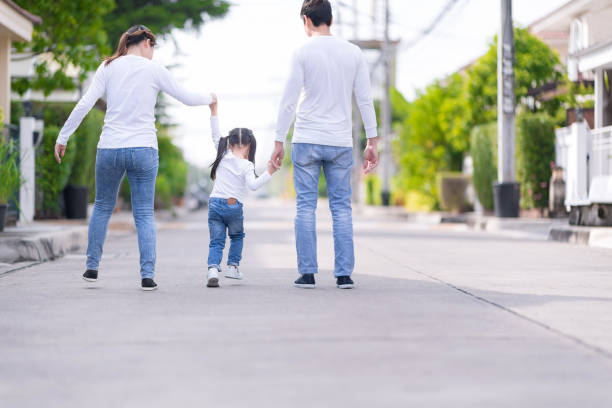 istock Parents and daughter are holding hands. Kid  going in the park. 936468770