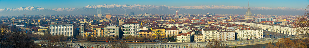 Panorama of Turin against backdrop of snowy Alps in sunny day, Italy