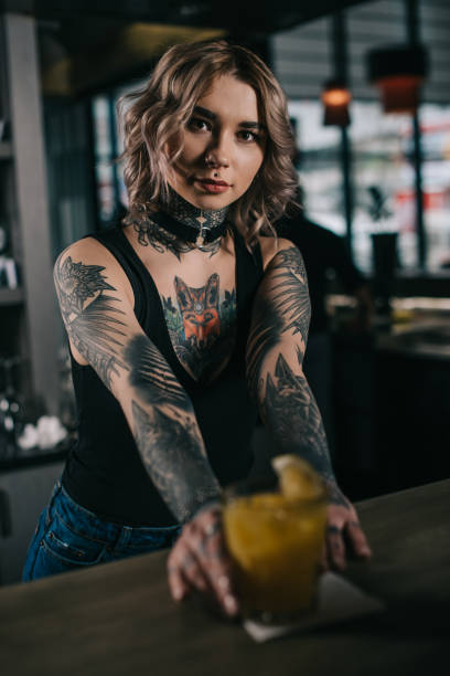 istock tattooed bartender holding alcohol cocktail at bar counter 936477958