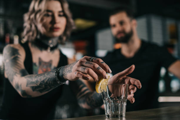 istock bartender putting piece of lemon in glass at bar 936478248