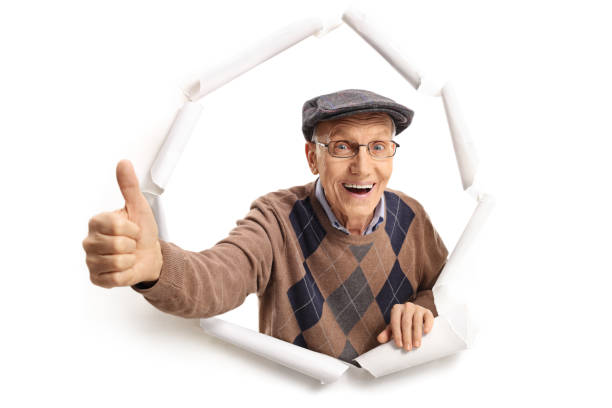 istock Cheerful senior breaking through paper 936487826