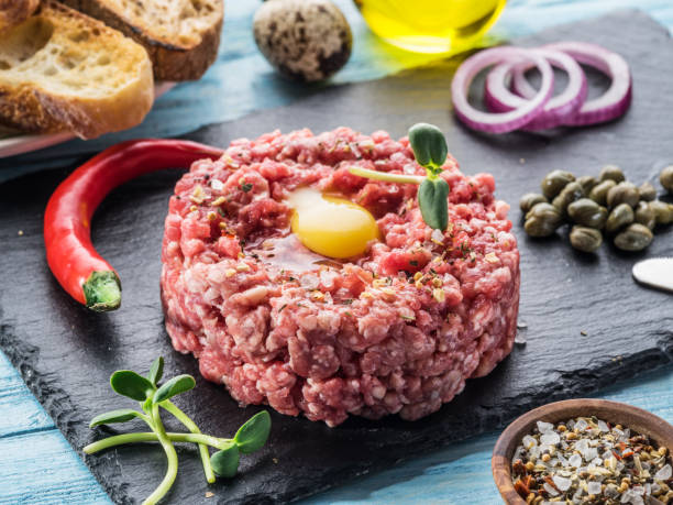 istock Steak tartare served with raw quail egg yolk, capers and bread. 936487886