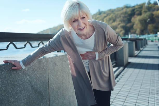 istock Retired lady doubling over due to severe pain 936487904