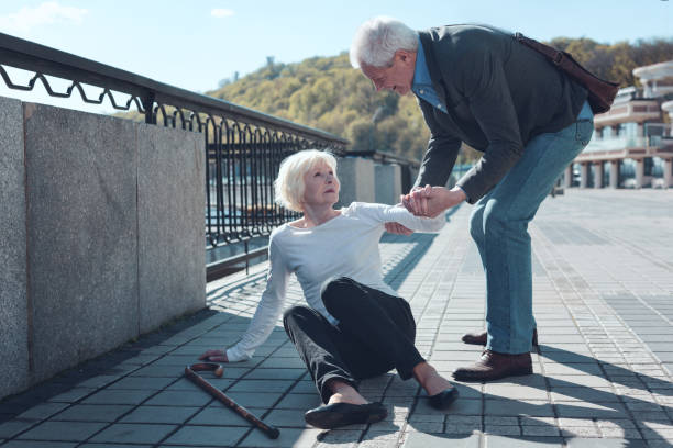 istock Mindful man helping elderly female stranger to stand up 936488656