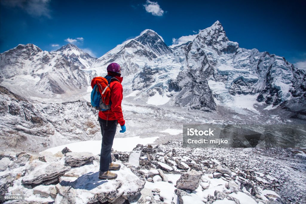 Woman looking at view on Himalayas Woman standing on top of Kala Patthar summit on Himalayan range and looking at beautiful view with mt. Everest and lhotse Mt. Everest Stock Photo