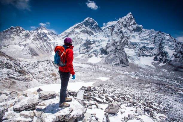 Woman looking at view on Himalayas Woman standing on top of Kala Patthar summit on Himalayan range and looking at beautiful view with mt. Everest and lhotse himalayas stock pictures, royalty-free photos & images