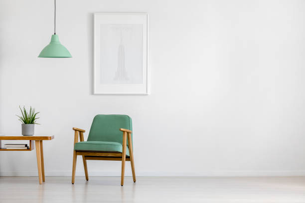 Retro armchair in bright interior Retro concept mint pastel armchair, wooden table and framed poster in a bright minimalist interior with copy space lounge chair photos stock pictures, royalty-free photos & images