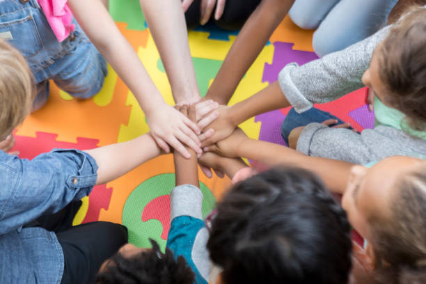 istock Group of schoolchildren with their hands together 936496662